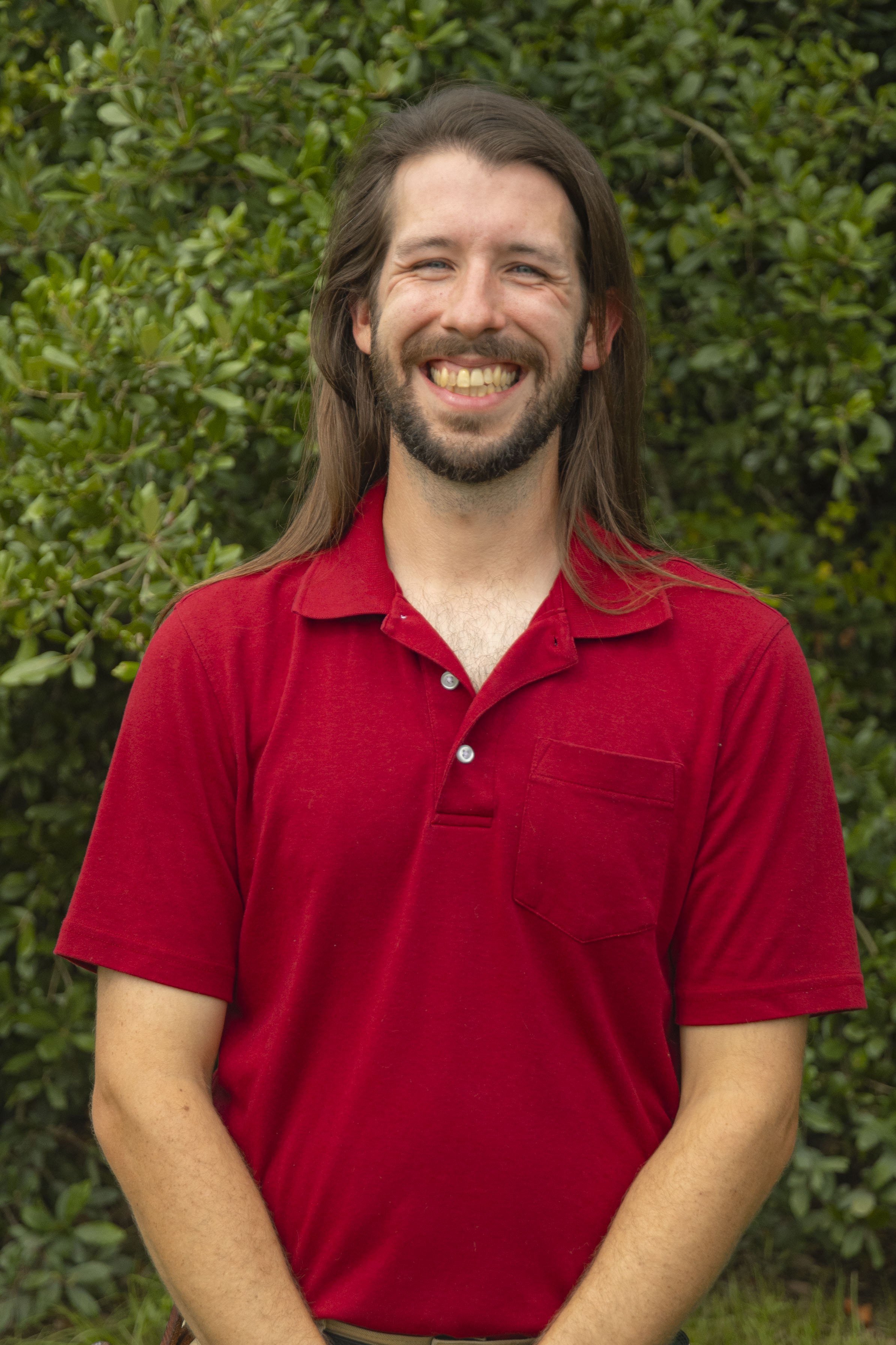 Image of Male. Erik Neff, Fluker's Chief Scientific Officer, in Red Shirt in front of trees 